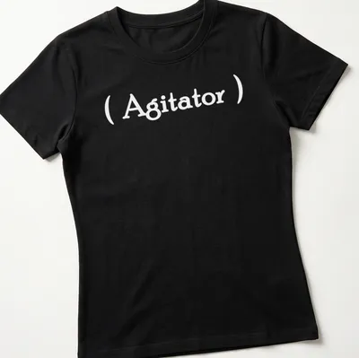 Minimalist Agitator t-shirt with bold white lettering on a simple background — printed on a women's shirt