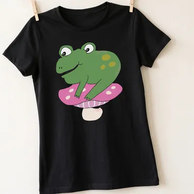 Cartoon frog sitting on a colorful toadstool, designed for kids — printed on a women's shirt
