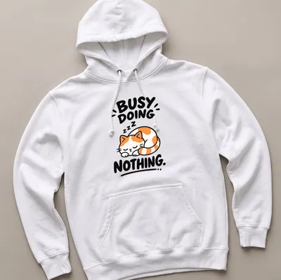 Kawaii line-art of a calico cat with text 'BUSY DOING NOTHING' in orange, white, black — printed on a unisex hoodie