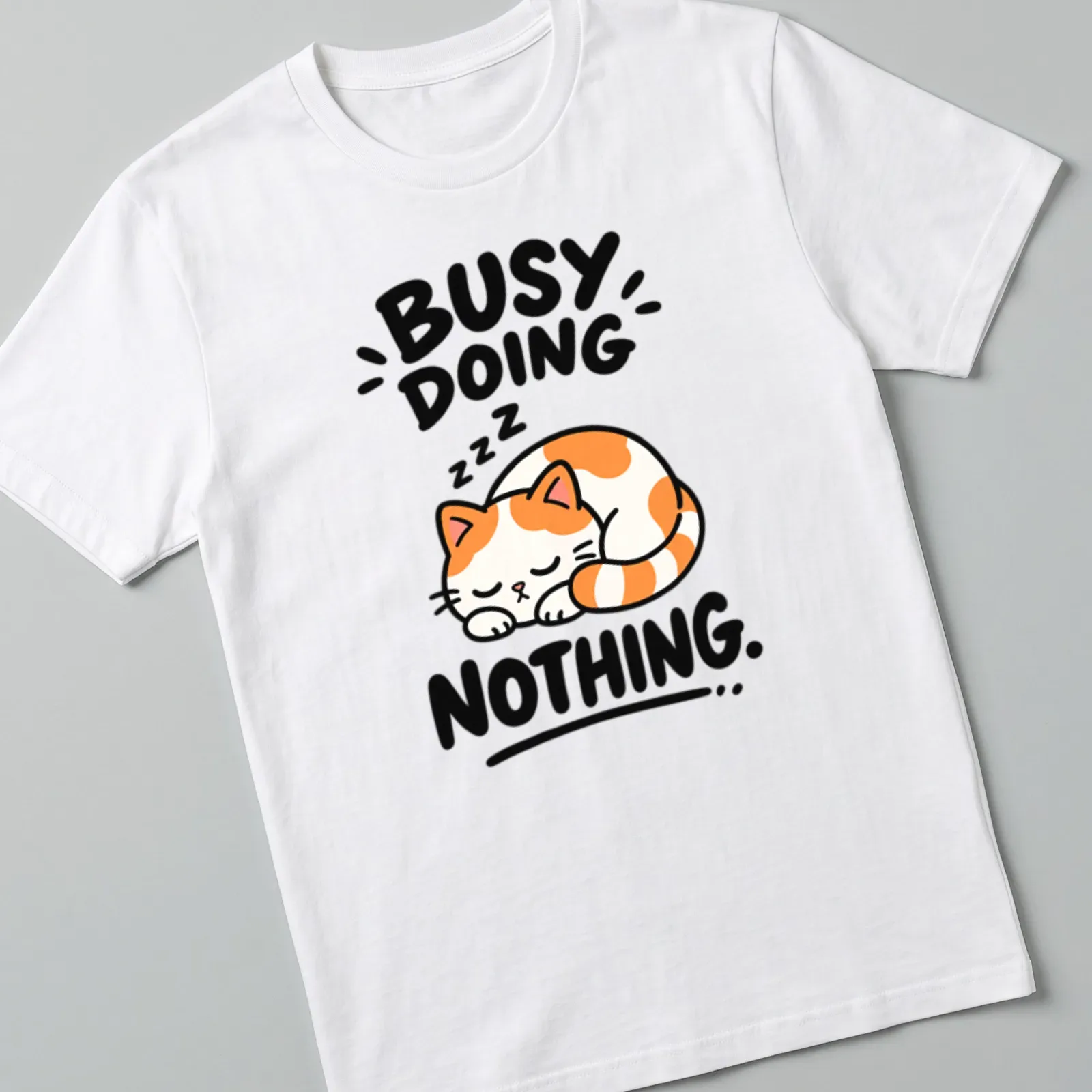 Kawaii line-art of a calico cat with text 'BUSY DOING NOTHING' in orange, white, black — printed on a unisex t-shirt