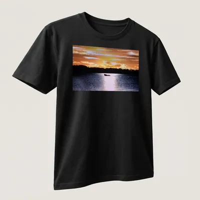 Boat silhouette against a colorful sunset in orange, yellow, and blue — printed on a unisex t-shirt (angled view)
