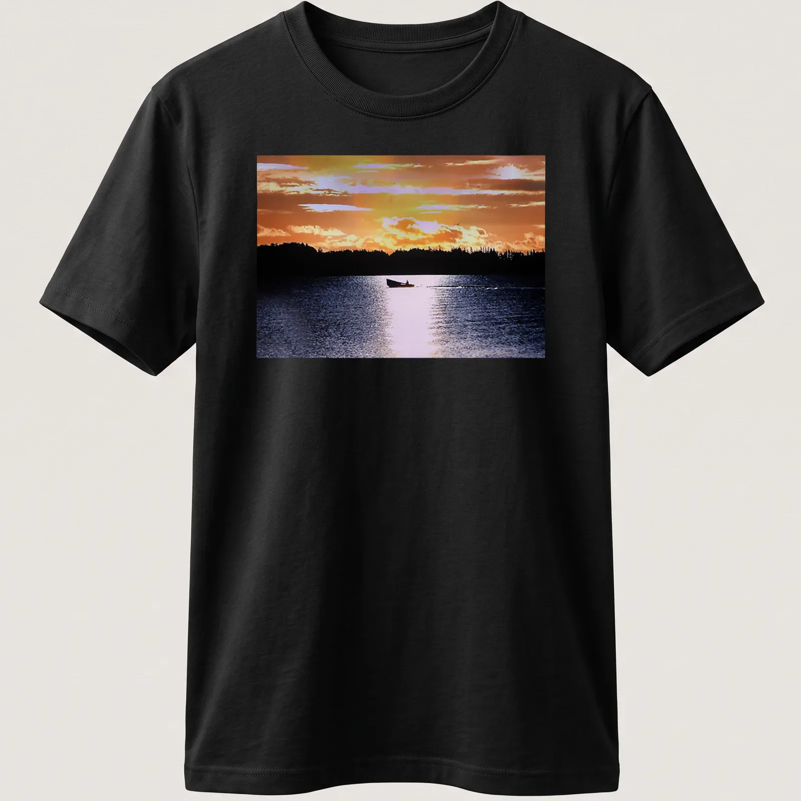 Boat silhouette against a colorful sunset in orange, yellow, and blue — printed on a unisex t-shirt