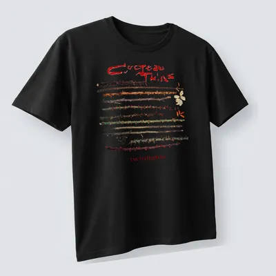 Vintage Cocteau Twins t-shirt featuring thorns around the text in earthy colors — printed on a unisex t-shirt (angled view)
