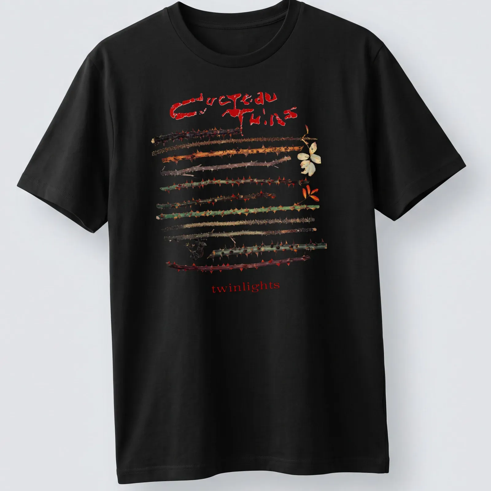 Vintage Cocteau Twins t-shirt featuring thorns around the text in earthy colors — printed on a unisex t-shirt