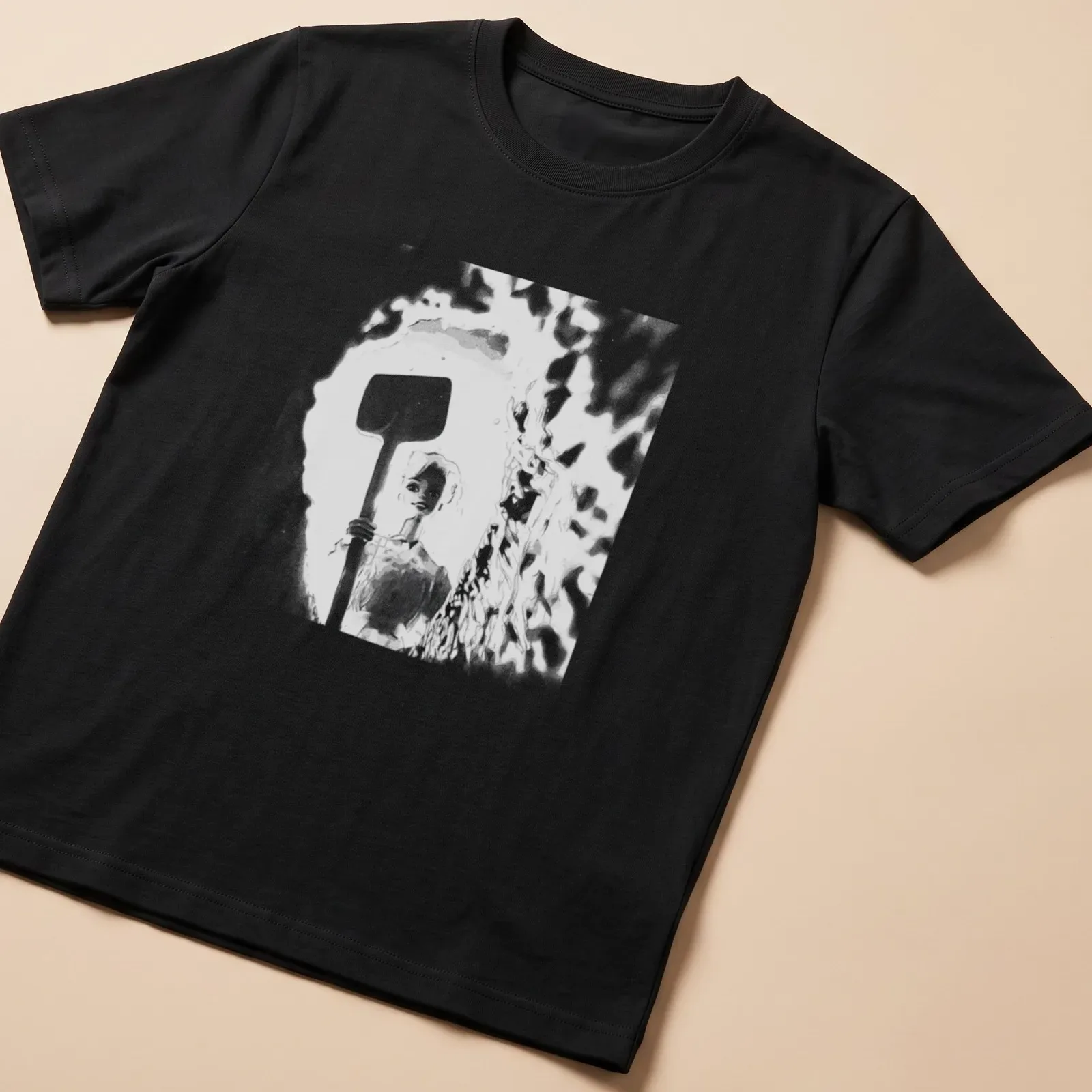 Distressed t-shirt featuring a doll holding a shovel in black, white, and gray — printed on a unisex t-shirt