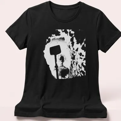 Distressed t-shirt featuring a doll holding a shovel in black, white, and gray — printed on a women's shirt