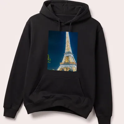 Photographic Eiffel Tower illuminated at night in gold, blue, and black — printed on a unisex hoodie