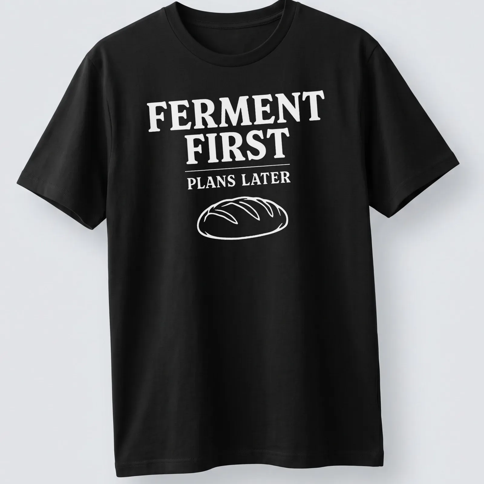 Bold typographic design shirt stating 'FERMENT FIRST PLANS LATER' with sourdough bread imagery — printed on a unisex t-shirt