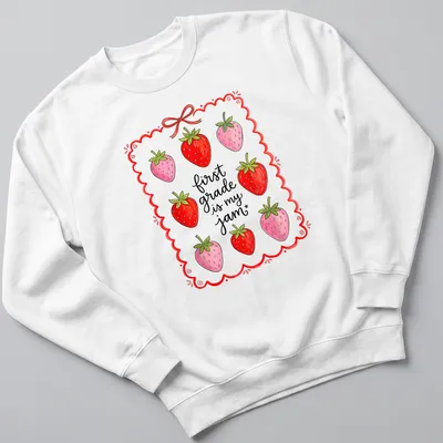 Whimsical illustration of strawberries with text 'first grade is my jam' in red and green — printed on a unisex sweatshirt