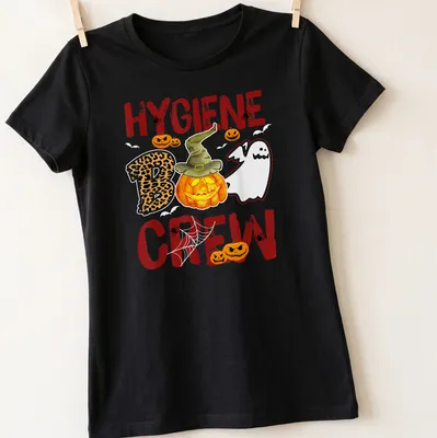 Whimsical illustration of a pumpkin and ghost with 'Hygiene Boo Crew' text — printed on a women's shirt