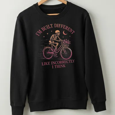 Vintage skeleton riding a bicycle with humorous text in pink and brown — printed on a unisex sweatshirt
