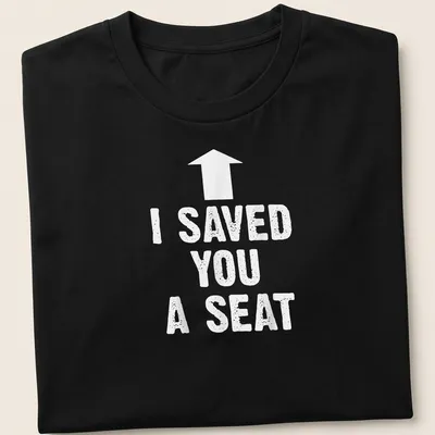 Humorous t-shirt with the text 'I SAVED YOU A SEAT' in bold typography