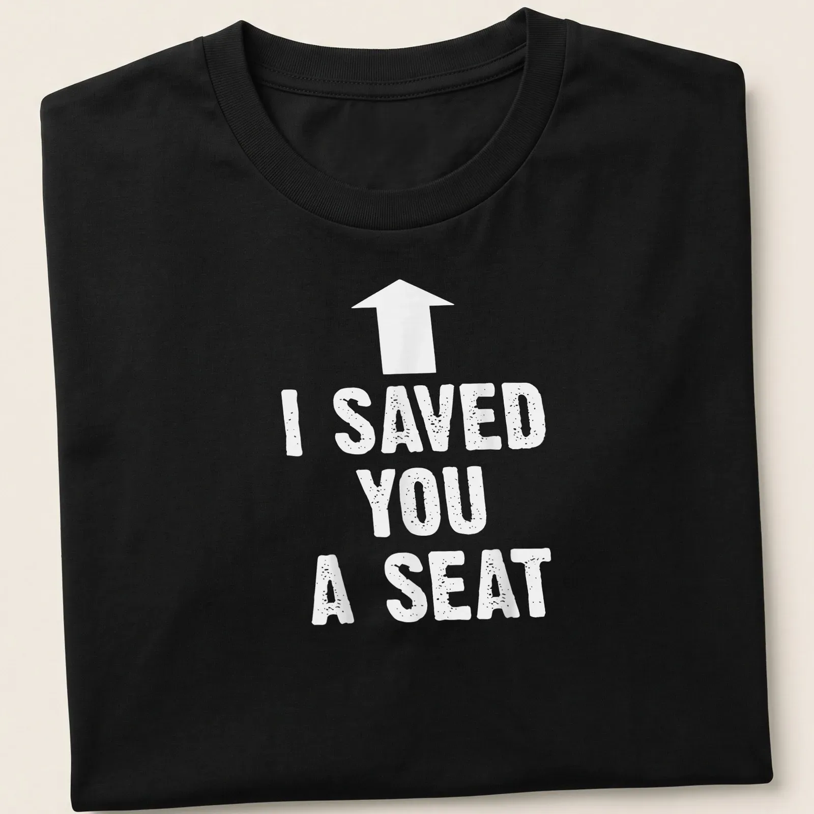 Humorous t-shirt with the text 'I SAVED YOU A SEAT' in bold typography — printed on a unisex t-shirt