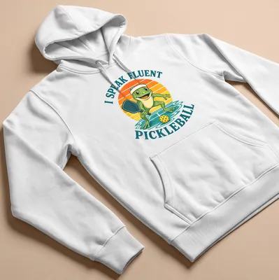 Vintage cartoon frog playing pickleball with humorous text about fluency — printed on a unisex hoodie