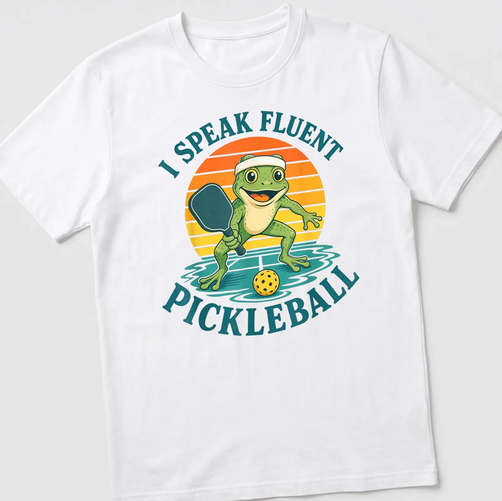 Vintage cartoon frog playing pickleball with humorous text about fluency — printed on a unisex t-shirt