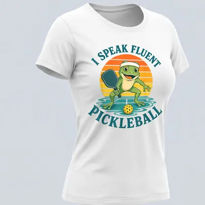Vintage cartoon frog playing pickleball with humorous text about fluency — printed on a women's shirt