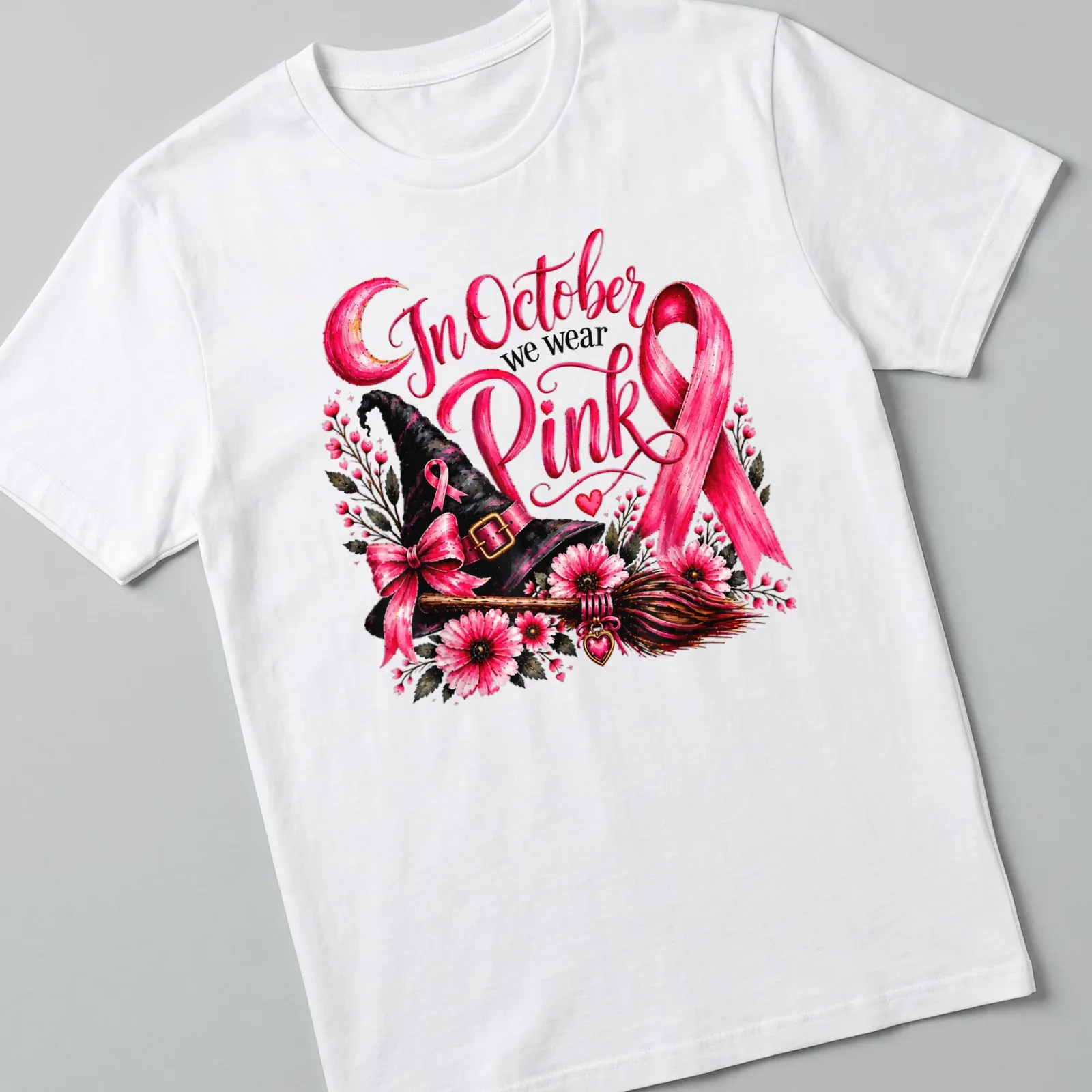 Vintage floral design of a pink witch hat and broom with the text In October we wear Pink — printed on a unisex t-shirt
