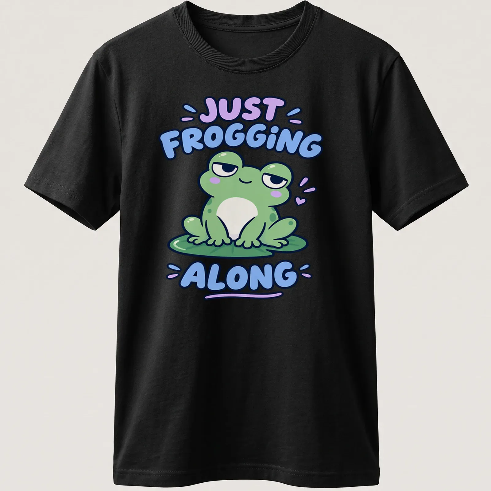 Kawaii design featuring a cute green frog with the phrase Just Frogging Along above it — printed on a unisex t-shirt