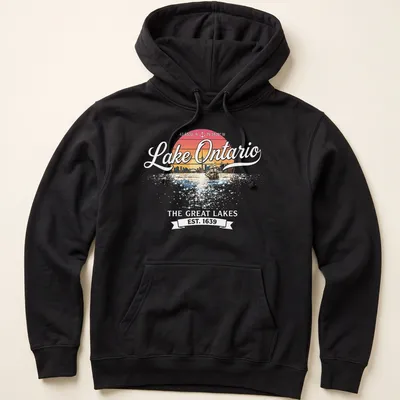 Retro sunset T-shirt featuring a sailboat and city skyline around Lake Ontario — printed on a unisex hoodie