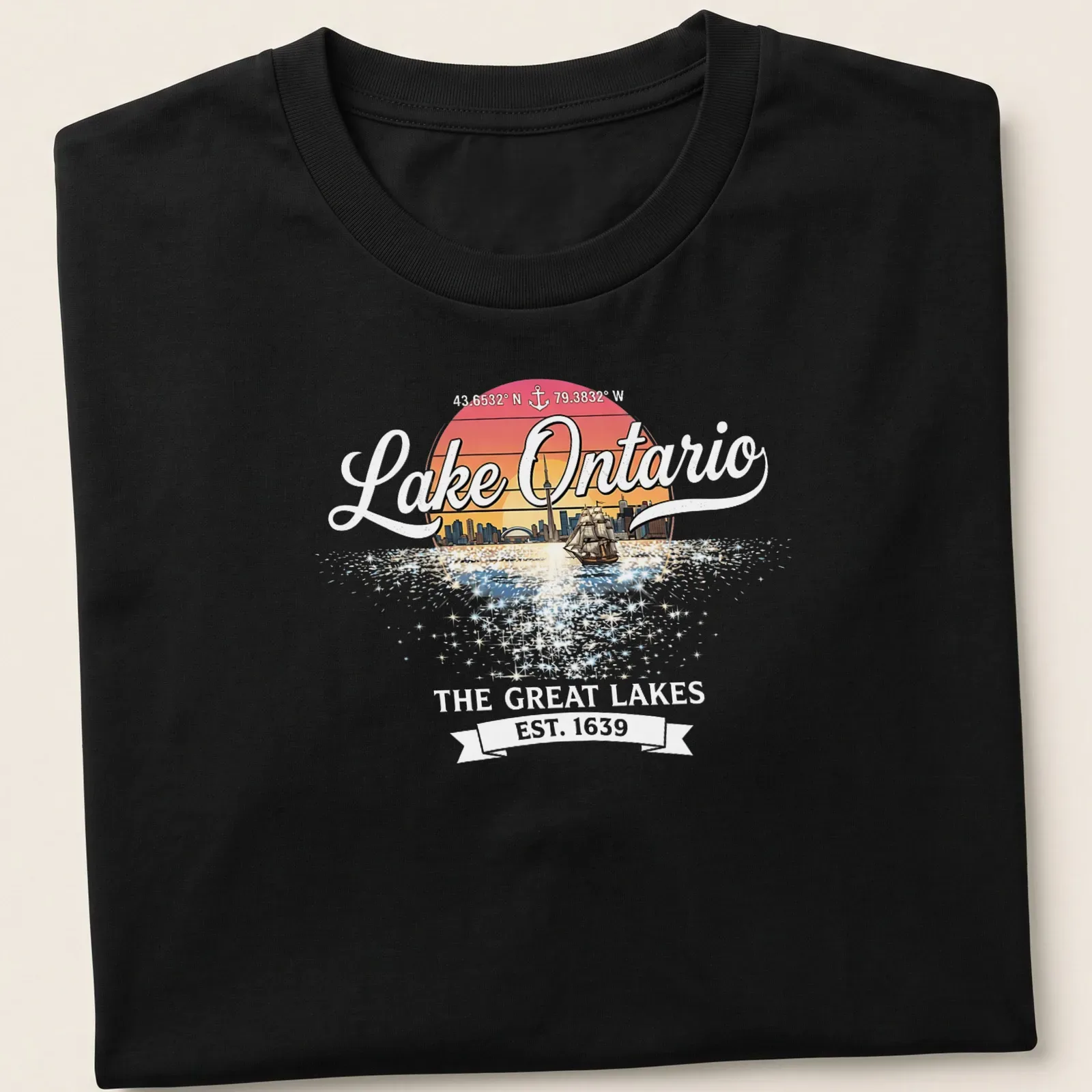 Retro sunset T-shirt featuring a sailboat and city skyline around Lake Ontario — printed on a unisex t-shirt