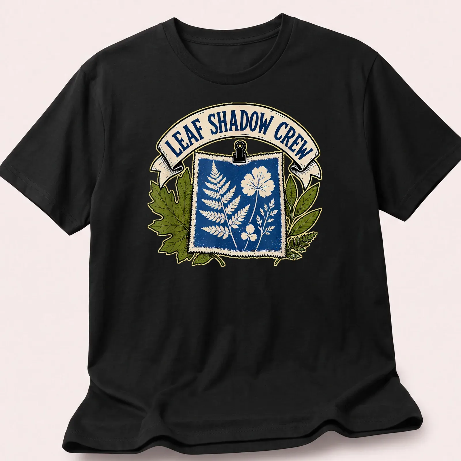 Cyanotype print of botanical leaves and flowers with the text 'Leaf Shadow Crew' — printed on a unisex t-shirt