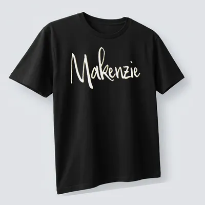 Personalized shirt featuring the name Makenzie in elegant gold script. — printed on a unisex t-shirt (angled view)