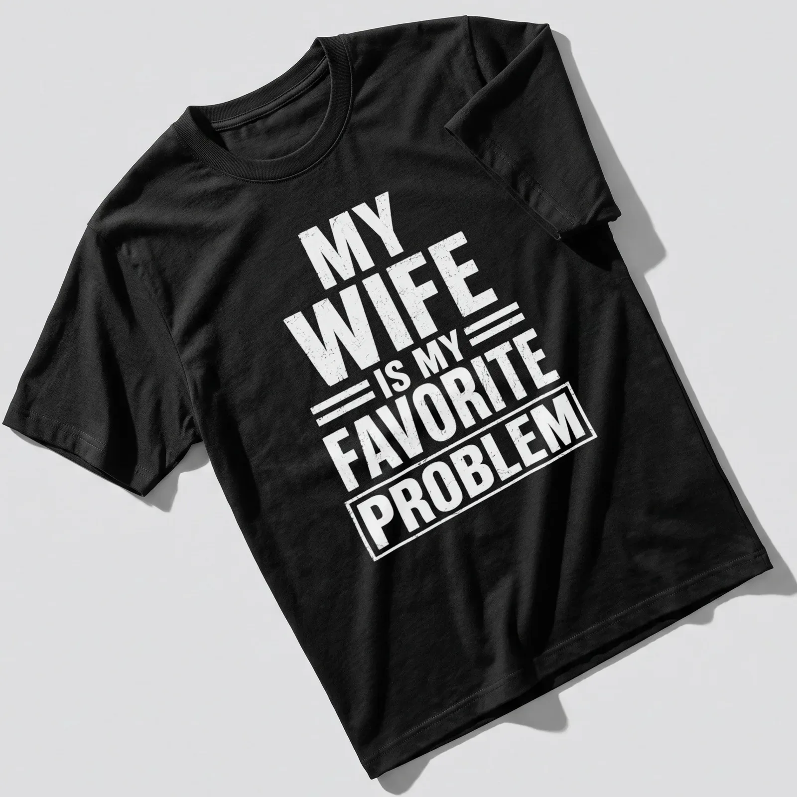 Bold typography tee with the phrase 'MY WIFE IS MY FAVORITE PROBLEM' in white — printed on a unisex t-shirt