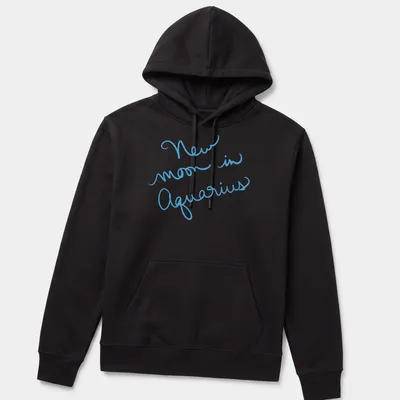 Handwritten script of New Moon in Aquarius on a light blue — printed on a unisex hoodie