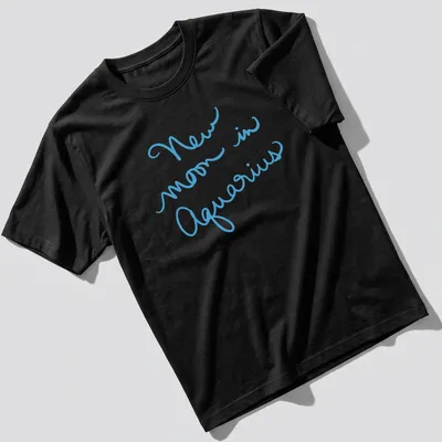 Handwritten script of New Moon in Aquarius on a light blue shirt