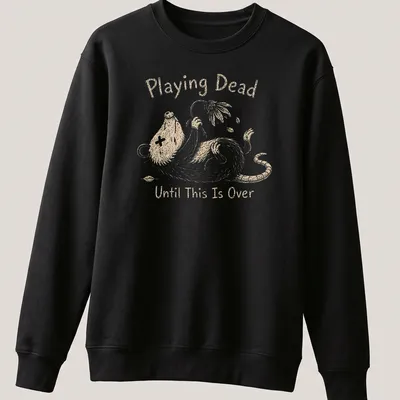 Whimsical illustration of an opossum with the text 'Playing Dead Until This Is Over' in soft colors — printed on a unisex sweatshirt