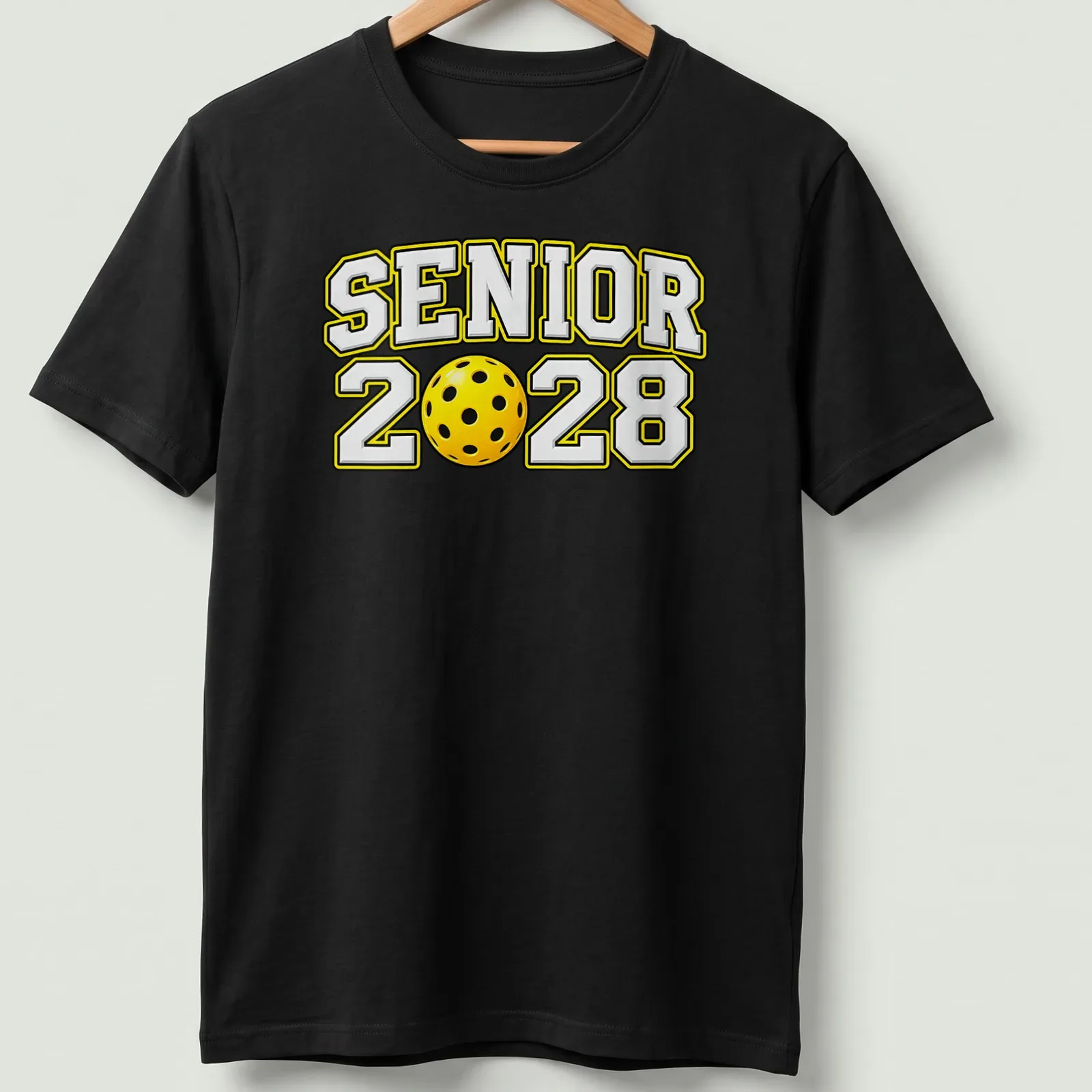 Bold text Senior 2028 with a pickleball graphic in yellow, black, and white — printed on a unisex t-shirt