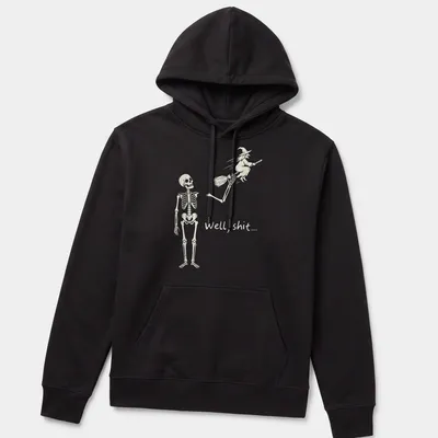 A humorous line-art print of a skeleton reacting to a flying witch with the text 'Well, shit...' — printed on a unisex hoodie