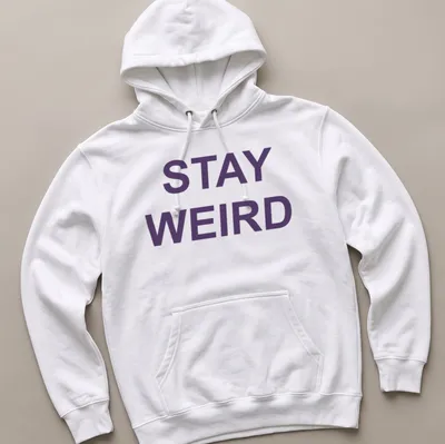 Purple t-shirt with the quote 'Stay Weird' in a playful font — printed on a unisex hoodie