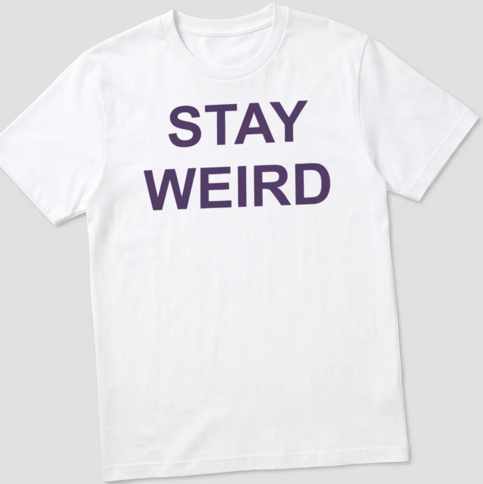 Purple t-shirt with the quote 'Stay Weird' in a playful font — printed on a unisex t-shirt