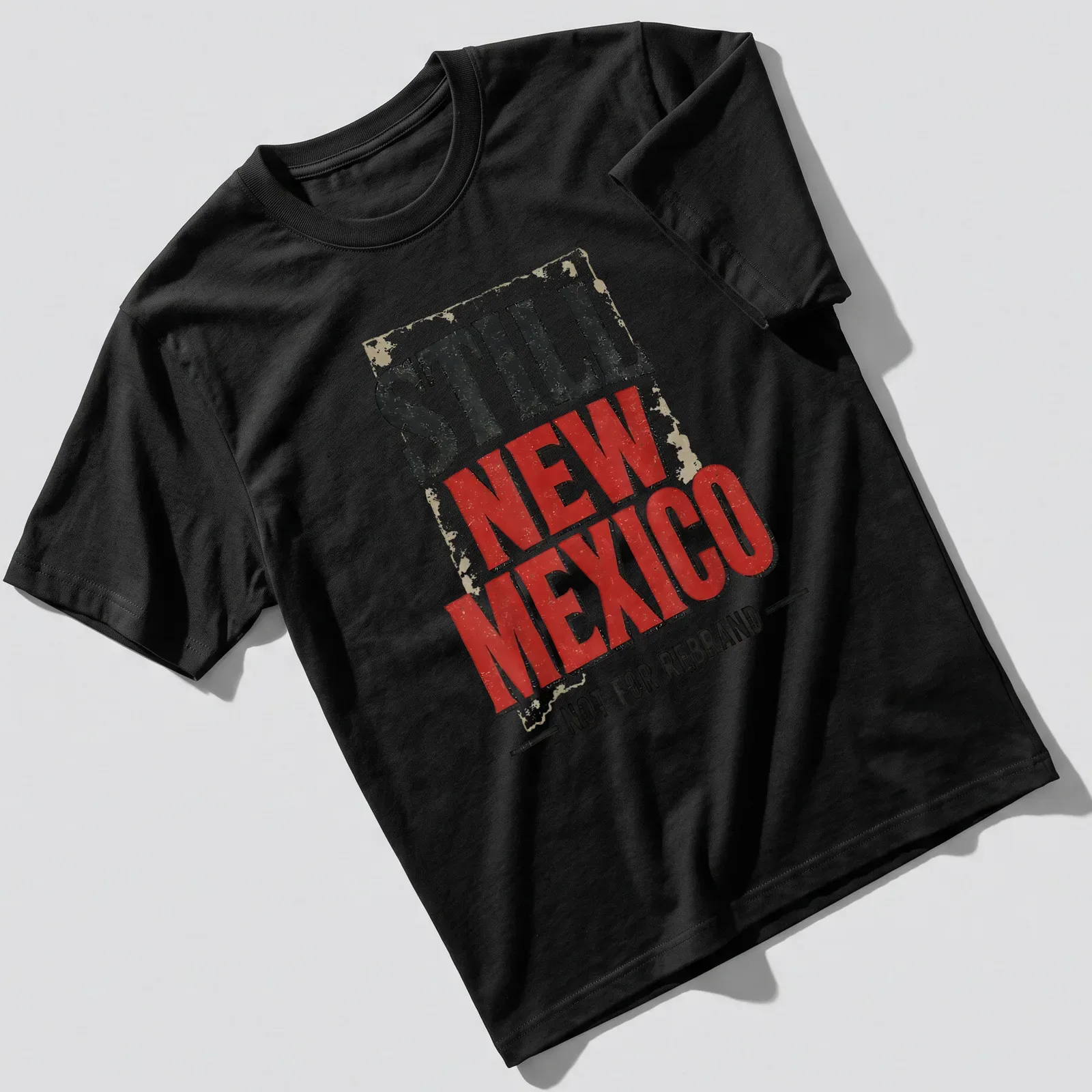 Vintage distressed t-shirt featuring the phrase 'Still New Mexico Not For Rebrand' in bold lettering. — printed on a unisex t-shirt