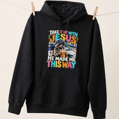 Colorful cartoon raccoon with humorous text, playful design — printed on a unisex hoodie