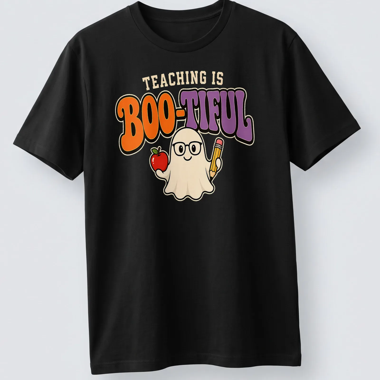 Kawaii ghost holding an apple and pencil with the text 'Teaching Is Boo-Tiful' in colorful design. — printed on a unisex t-shirt