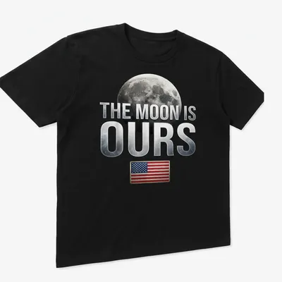 Graphic t-shirt featuring the phrase 'The Moon Is Ours' with a moon and American flag — printed on a unisex t-shirt (angled view)