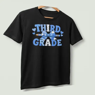 Patchwork design featuring 'THIRD GRADE', a blue bow, and a pencil. — printed on a unisex t-shirt (angled view)