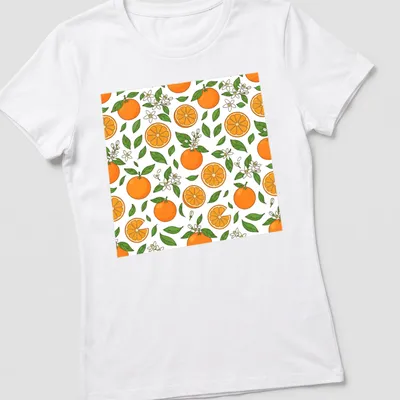 Colorful pattern featuring orange fruits and blossoms in orange and green — printed on a women's shirt