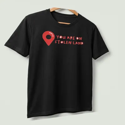 Bold text design on a shirt with a map pin graphic, red and white colors — printed on a unisex t-shirt (angled view)